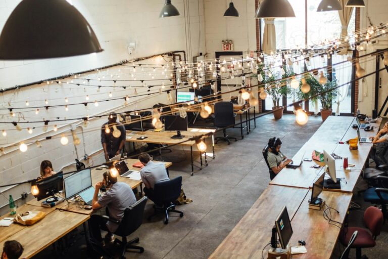 Coworking Kosten absetzen: Selbstständige arbeiten in einem hellen Coworking-Space