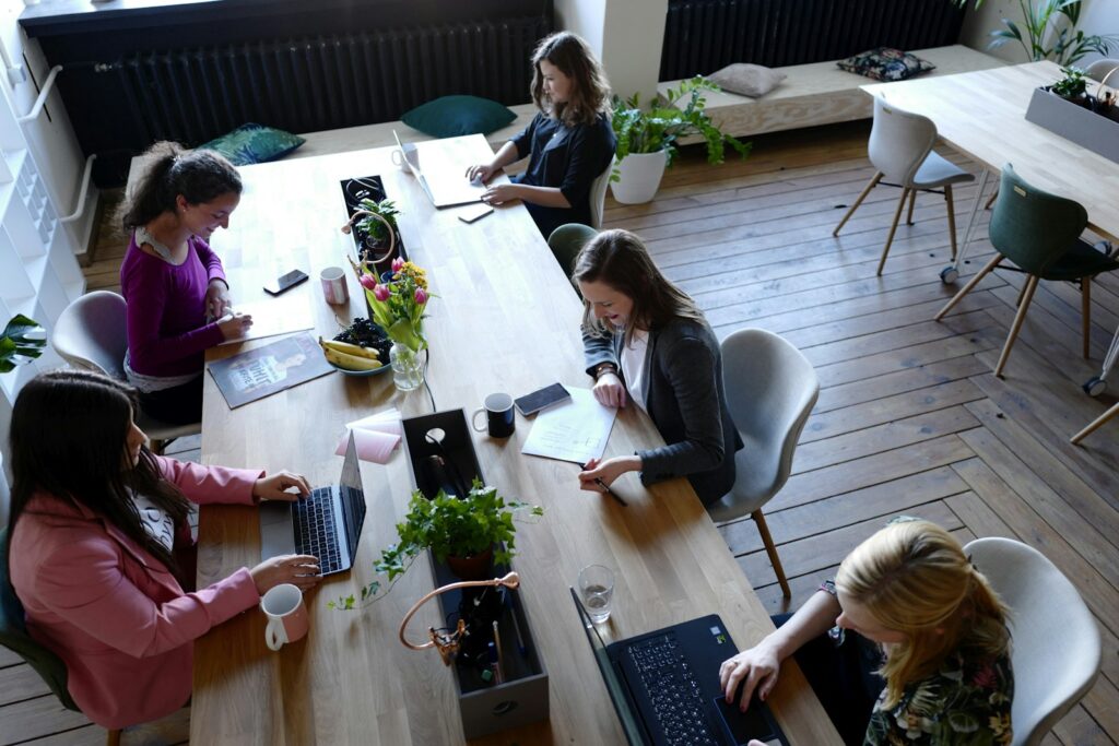 Coworking Kosten absetzen: Freiberufler arbeiten an Gemeinschaftstischen im Coworking-Space