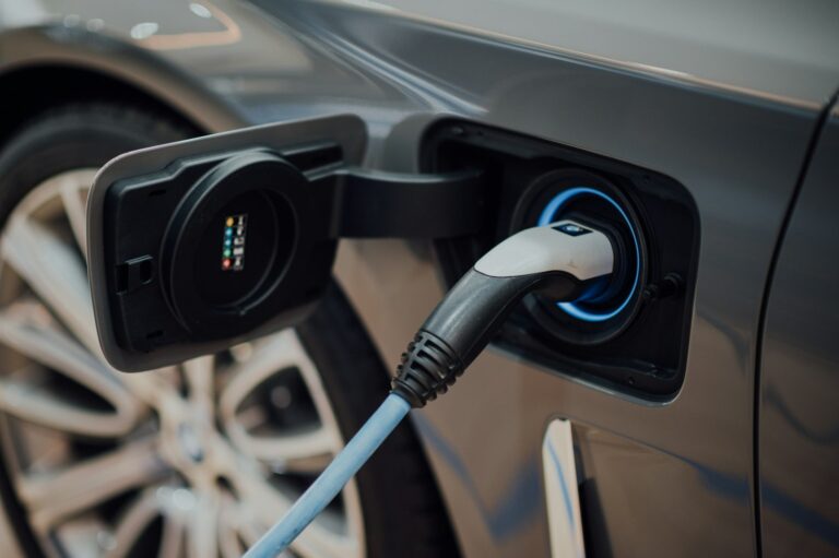 Dienstwagen versteuern: Firmenwagen mit Elektroantrieb an einer Ladestation auf dem Firmenparkplatz