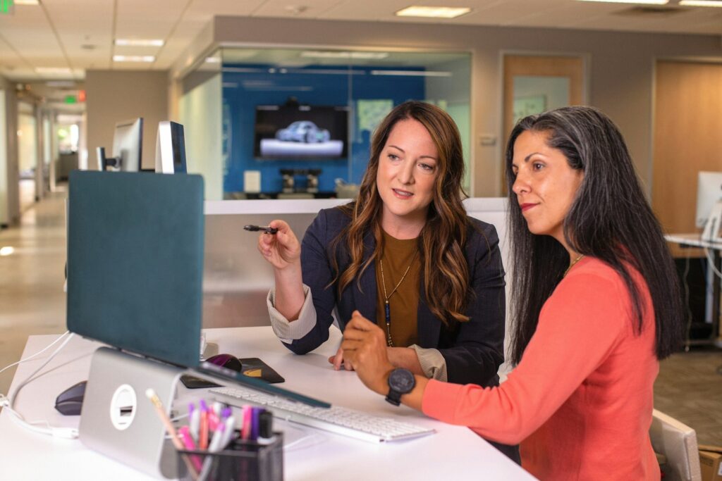 Jobsharing Führungsposition: Zwei Kolleginnen stimmen sich im Büro über Entscheidungen ab