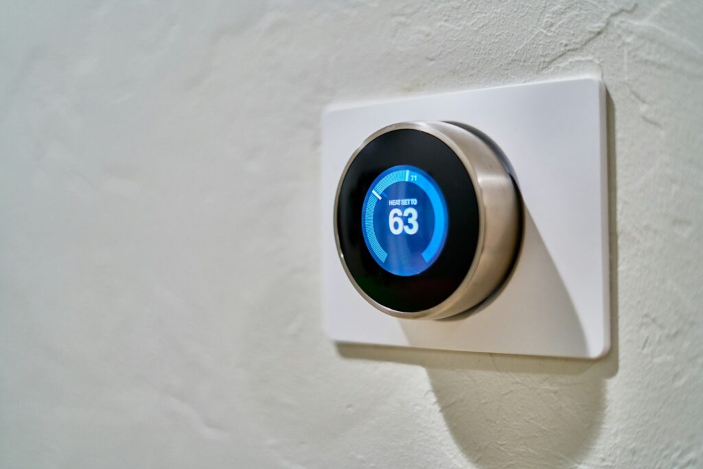 Raumtemperatur am Arbeitsplatz einstellen: Hand regelt das Thermostat im Büro