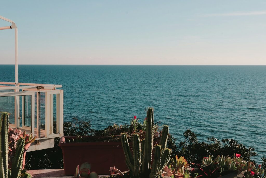 Workation Regelung: Laptop auf einer Terrasse am Meer als mobiler Arbeitsplatz